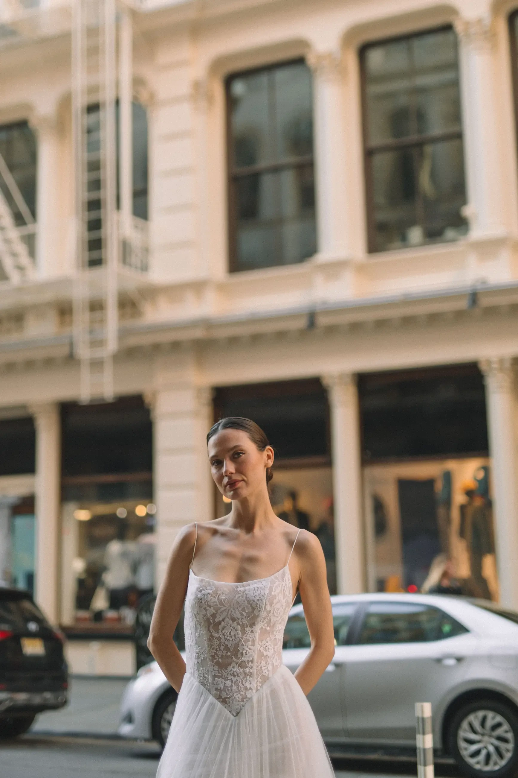 model is wearing a sleeveless lace bridal gown