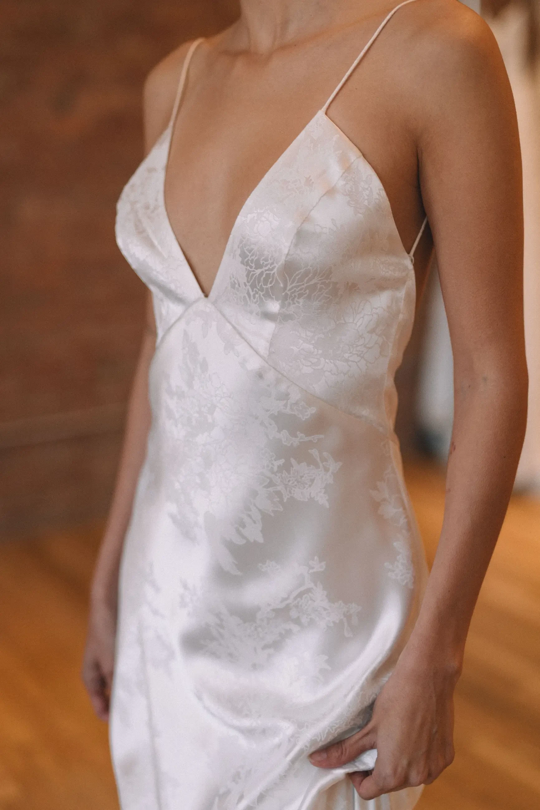 model is wearing a sleeveless plunging wedding dress