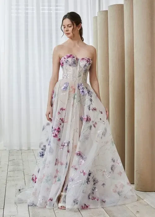Model is wearing a hand painted wedding dress with a strapless, structured bodice 