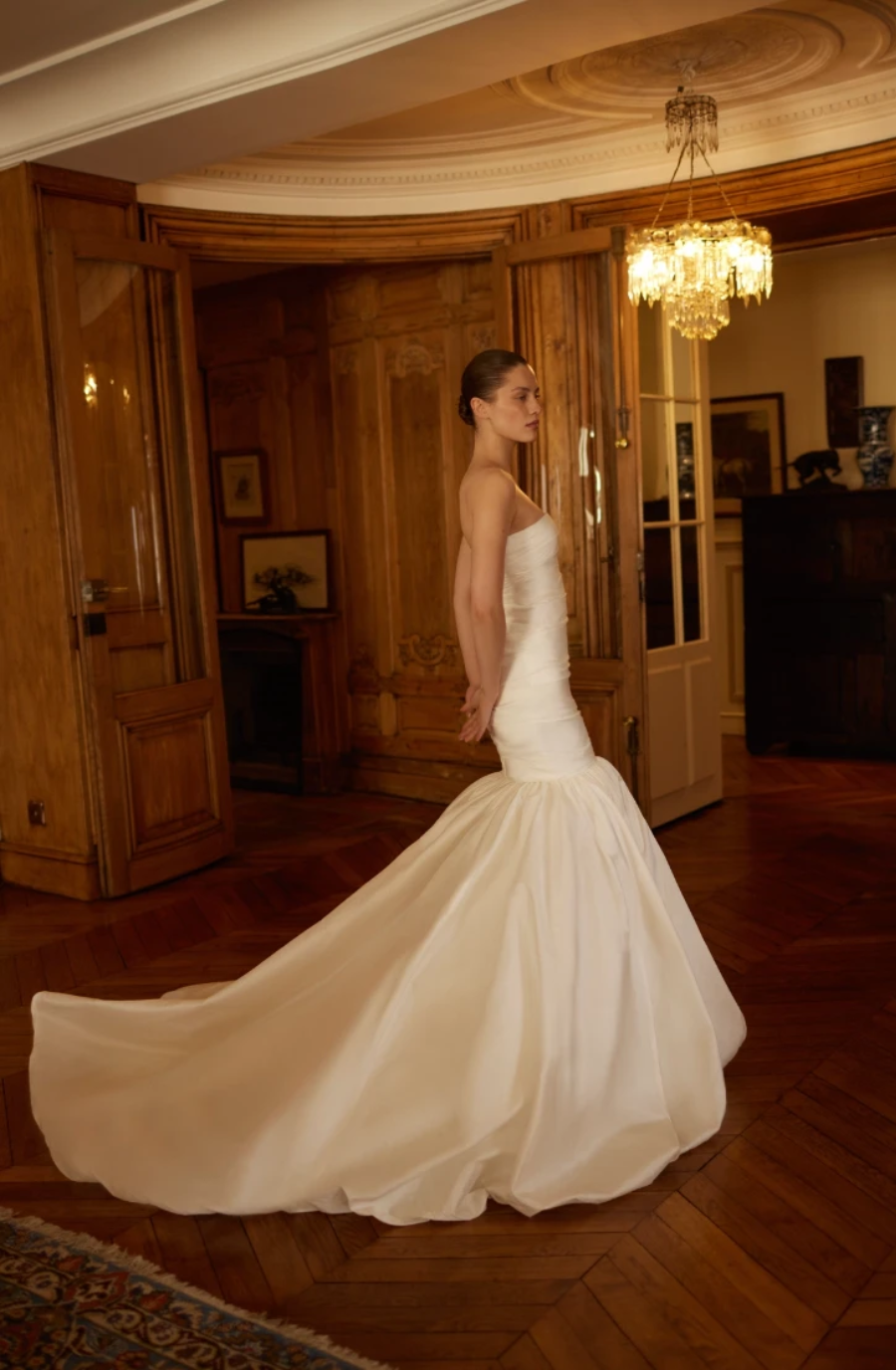 model is wearing a strapless mermaid wedding gown