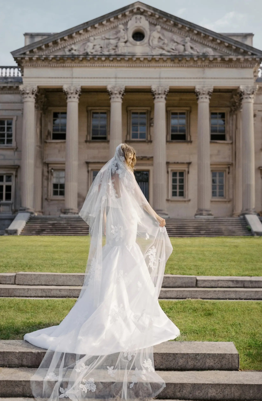 model is wearing a sleeveless trumpet bridal gown with a square neckline