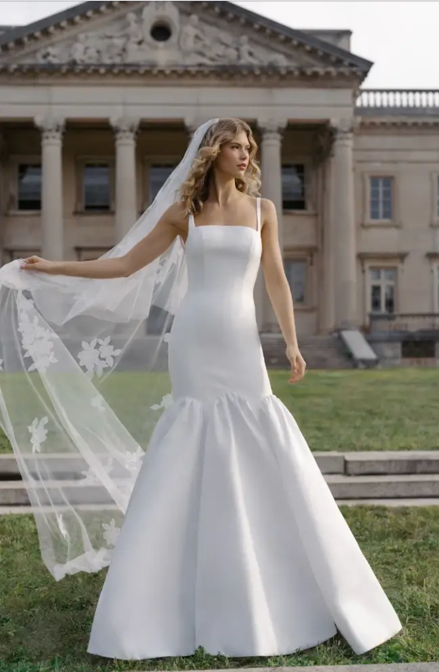 model is wearing a sleeveless trumpet bridal gown with a square neckline