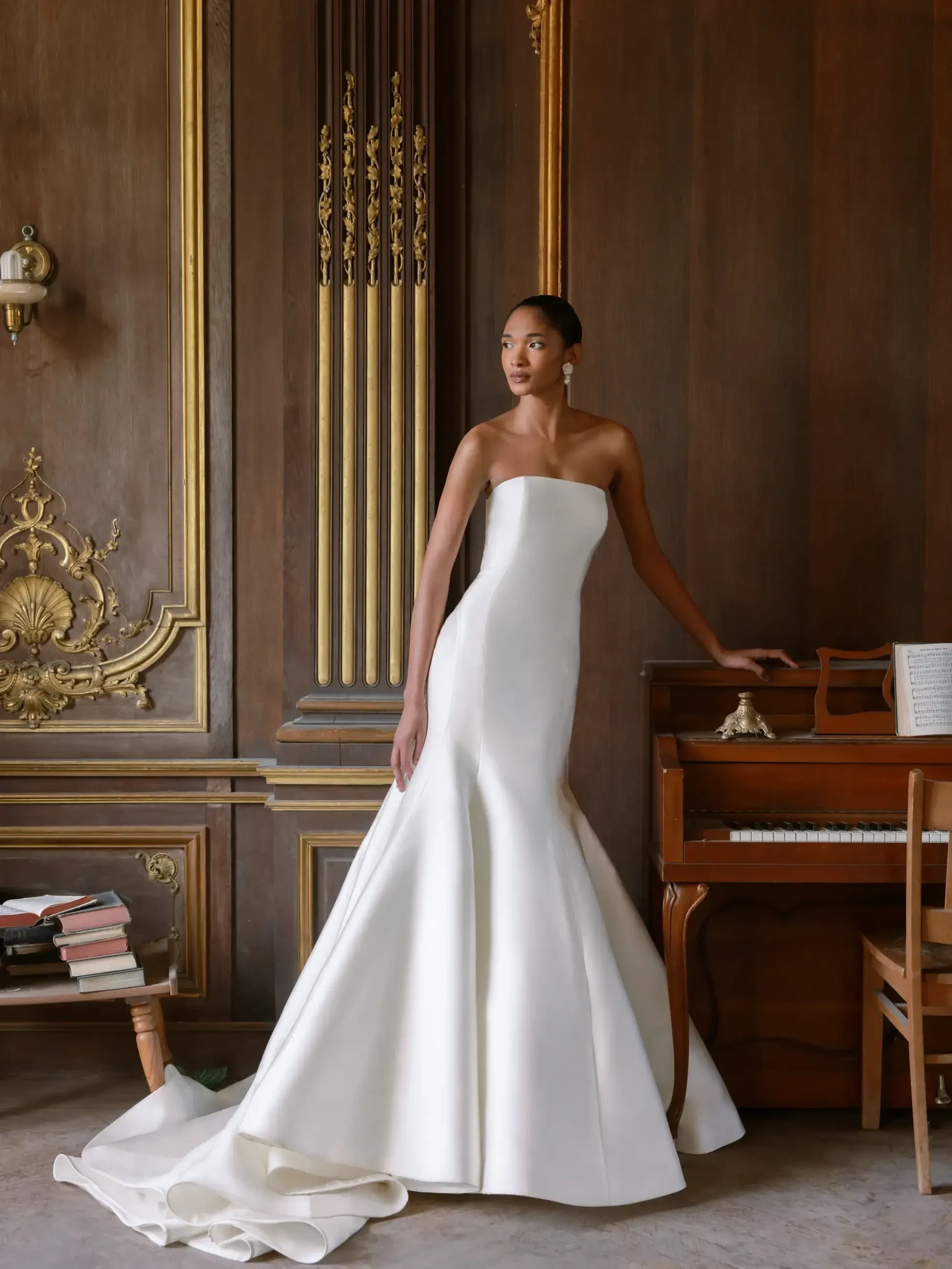 Model is wearing a strapless Italian Magnolia fit and flare gown with a straight-edge neckline and detailed seamwork for a sleek, figure-flattering silhouette.