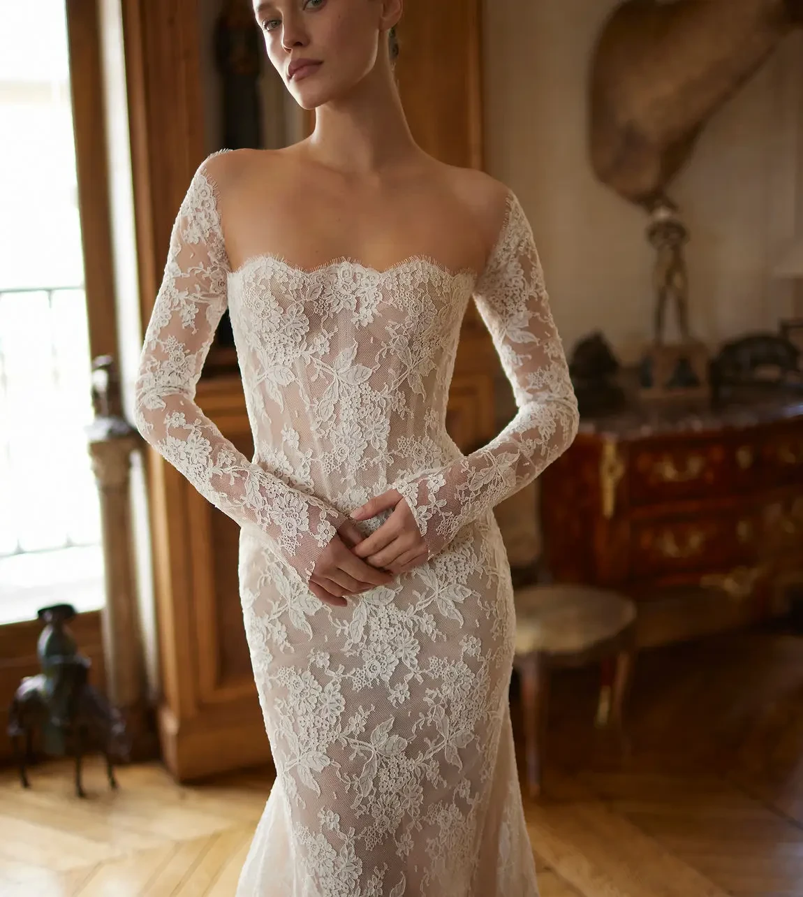 model is wearing a strapless lace bridal gown with off the shoulder detachable gauntlet sleeves