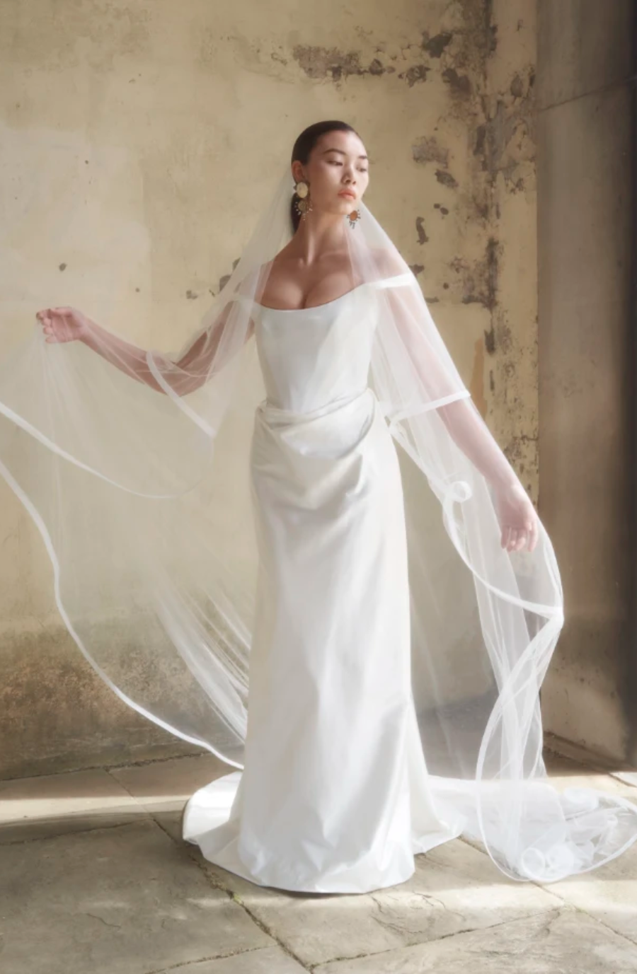 model is wearing an off the shoulder fit & flare bridal gown