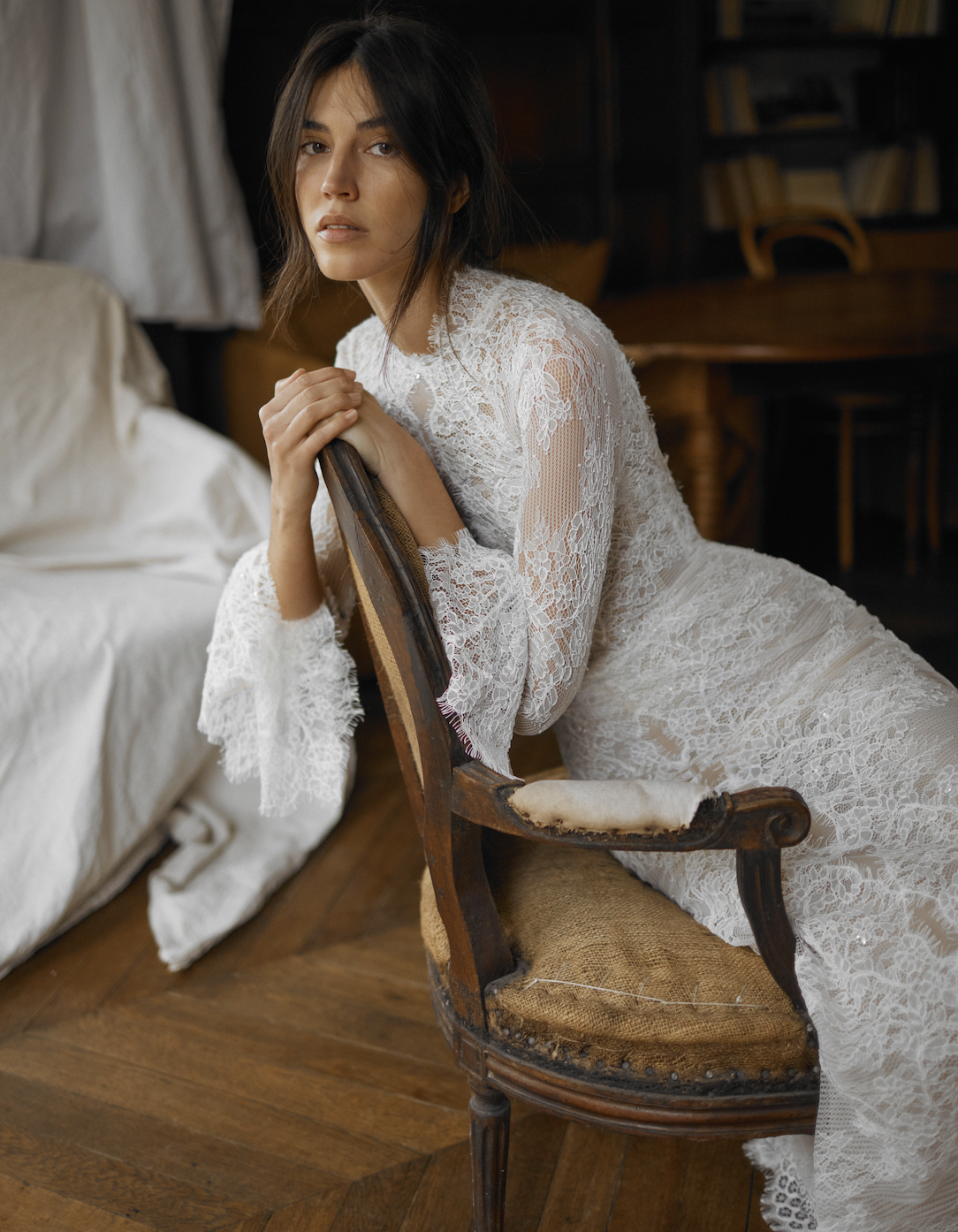 model is wearing a long sleeve lace dana harel wedding dress