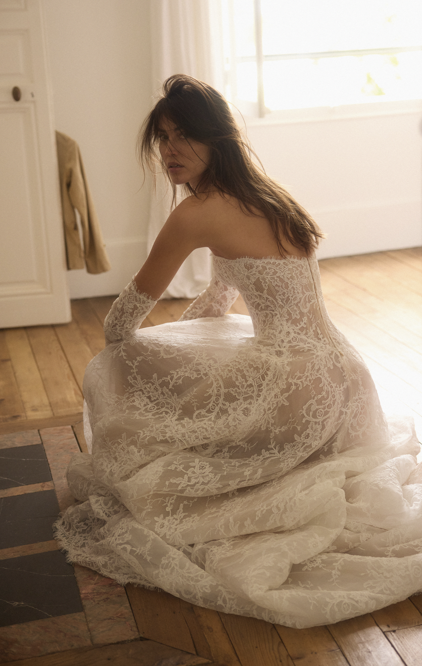 model is wearing a strapless lace dana harel bridal gown