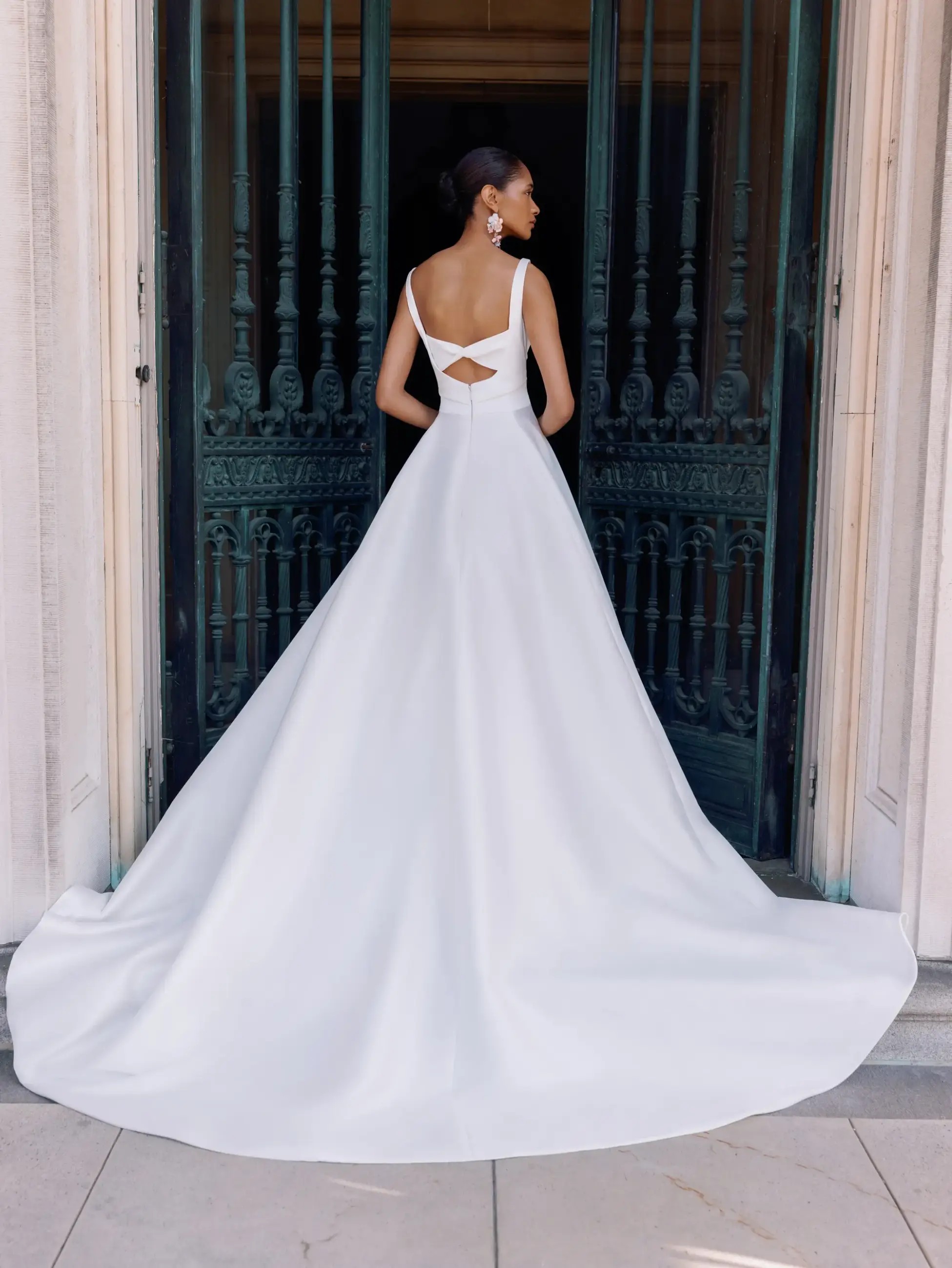 Model is wearing a minimalist mikado wedding dress with a high slit and scoop neckline by sarah nouri