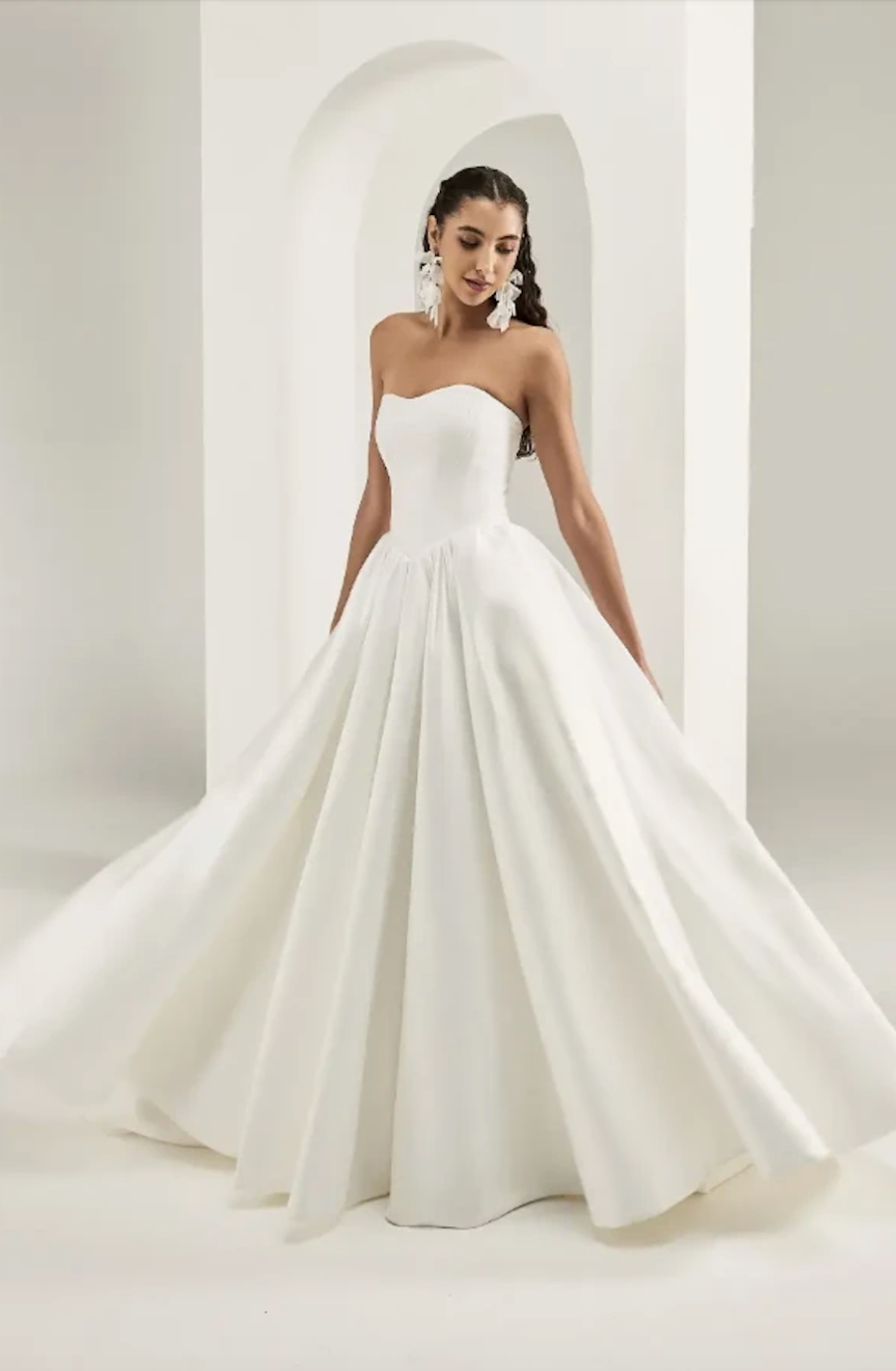 model is wearing a strapless ball gown wedding dress